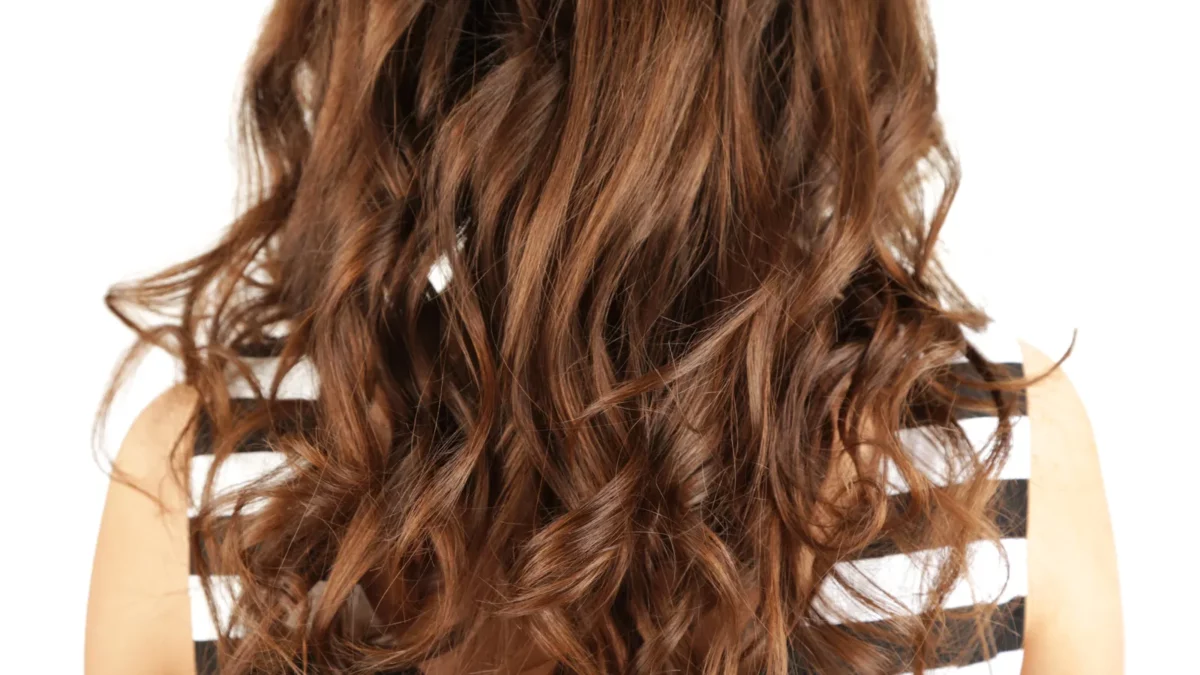 Woman with curly long hair with chocolate brown babylights