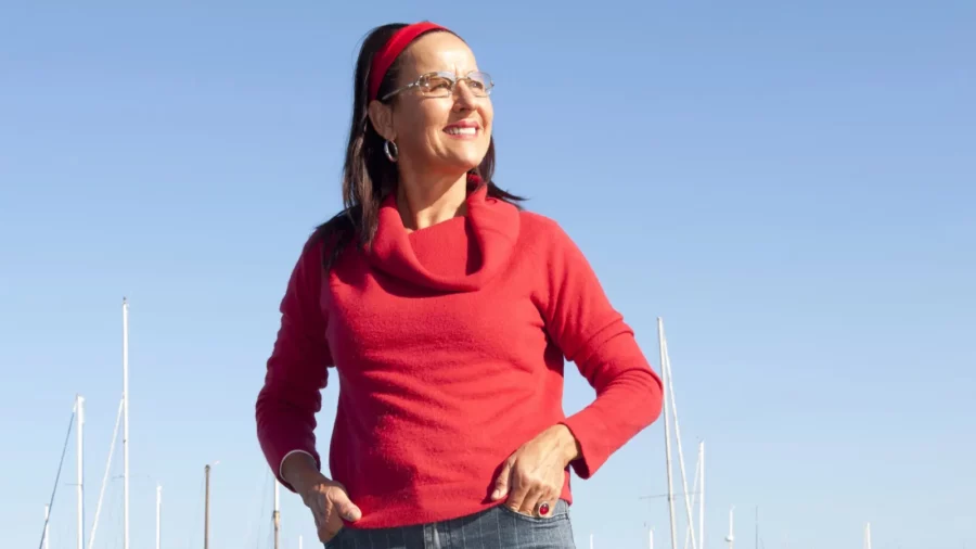 Relaxed happy mature woman in red outfit near ocean